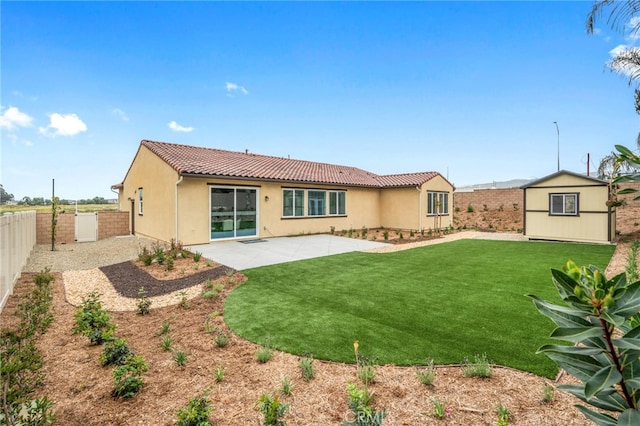 back of house with stucco siding, a tiled roof, an outbuilding, a fenced backyard, and a patio area