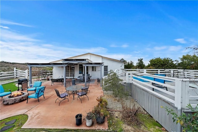 view of patio featuring a fire pit and fence