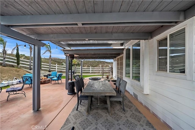 view of patio with a fire pit and fence