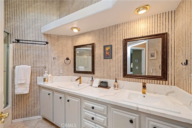 full bath with tile patterned flooring, an enclosed shower, wallpapered walls, and a sink