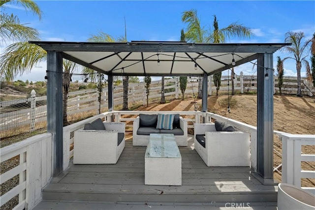 wooden terrace featuring a gazebo, outdoor lounge area, and fence