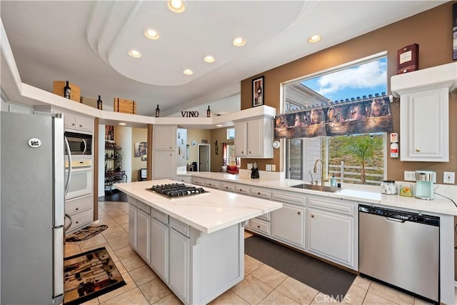 kitchen featuring recessed lighting, appliances with stainless steel finishes, light tile patterned flooring, white cabinets, and a sink