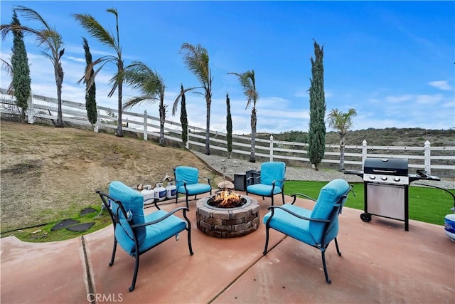 view of patio / terrace featuring grilling area, fence, and an outdoor fire pit