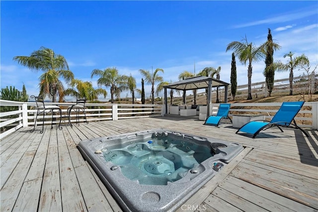 deck featuring a gazebo and hot tub deck surround