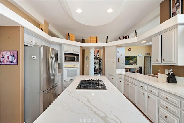 kitchen with white cabinetry, light stone countertops, recessed lighting, and appliances with stainless steel finishes