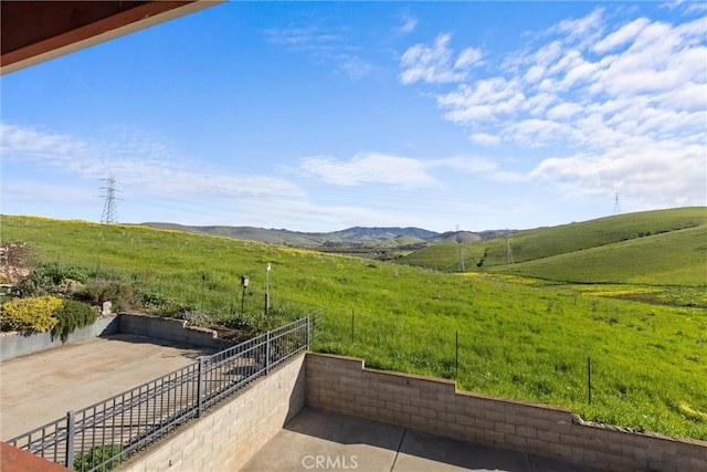 exterior space with fence, a rural view, and a mountain view