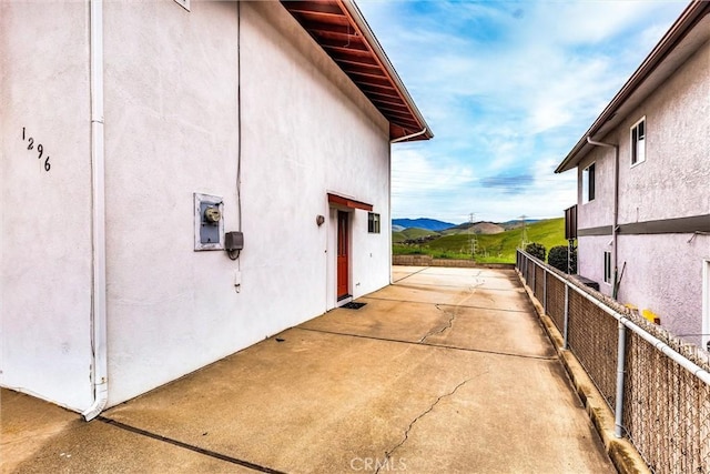 view of property exterior with a patio area, a mountain view, and stucco siding