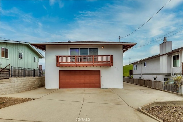 view of front of home featuring stucco siding, an attached garage, driveway, and fence