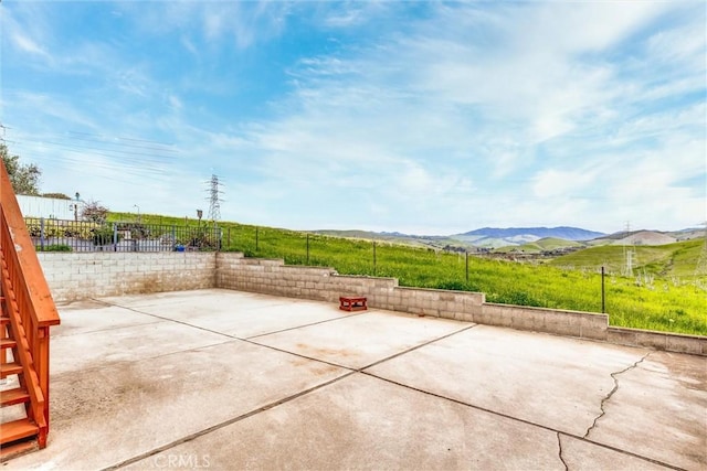 view of patio / terrace featuring fence and a mountain view