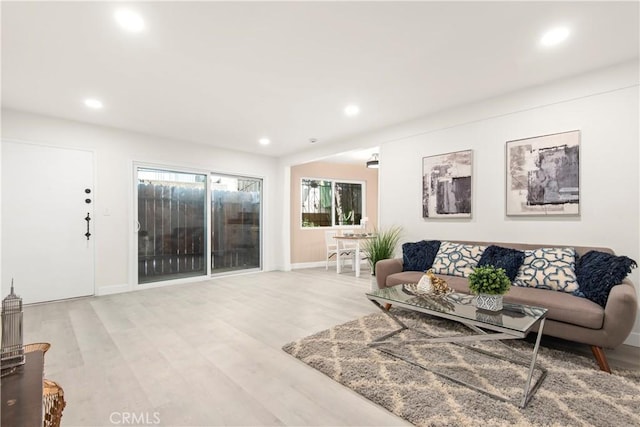 living area featuring recessed lighting, light wood-type flooring, and baseboards