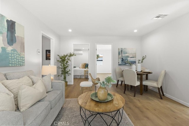 11541 Basye St, El Monte, CA 91732 - living area with a wall unit AC, visible vents, baseboards, light wood-style flooring, and recessed lighting