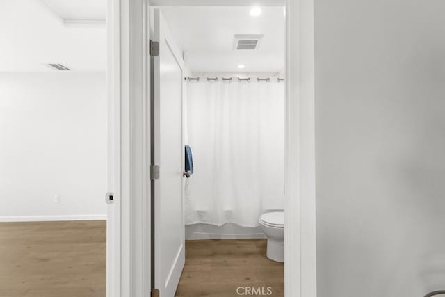11541 Basye St, El Monte, CA 91732 - bathroom featuring visible vents, shower / bath combo with shower curtain, toilet, wood finished floors, and baseboards
