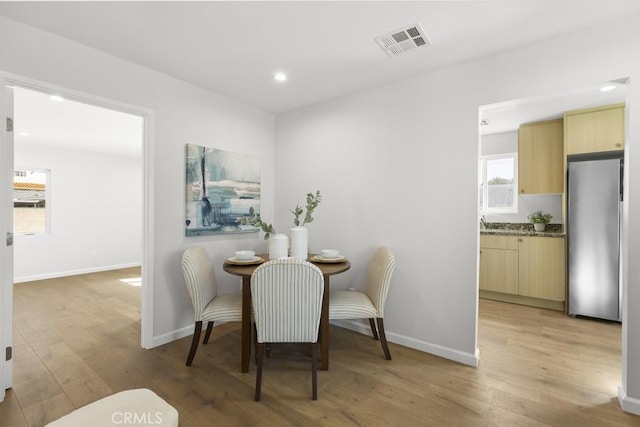 11541 Basye St, El Monte, CA 91732 - dining area with visible vents, baseboards, and light wood-style flooring
