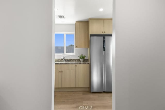 11541 Basye St, El Monte, CA 91732 - kitchen with light wood-type flooring, visible vents, light brown cabinets, a sink, and freestanding refrigerator