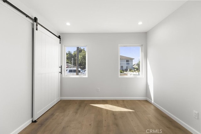 11541 Basye St, El Monte, CA 91732 - unfurnished bedroom with recessed lighting, baseboards, a barn door, and wood finished floors