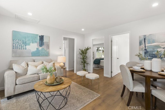 living area featuring recessed lighting, baseboards, and wood finished floors