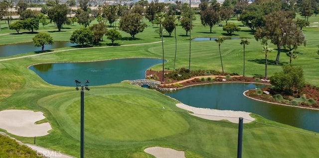 view of community featuring a yard, a water view, and view of golf course