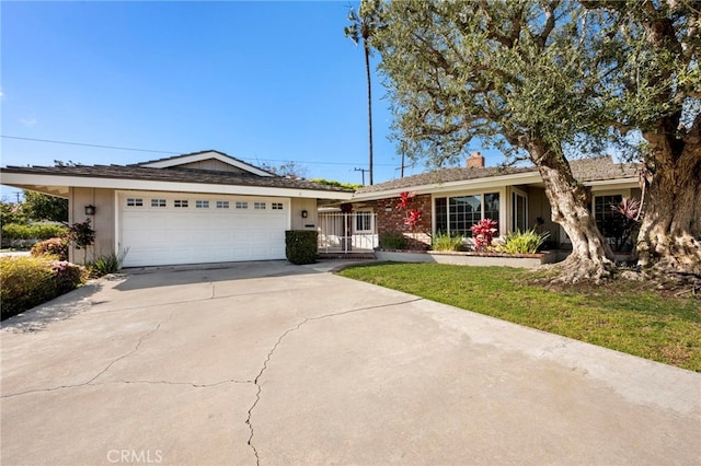 single story home featuring a garage, a chimney, driveway, and stucco siding