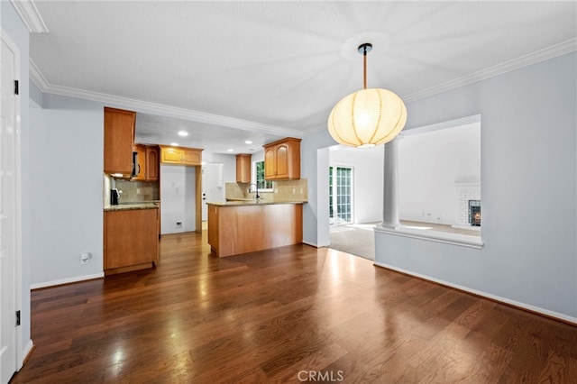 kitchen with open floor plan, dark wood-style flooring, and ornamental molding