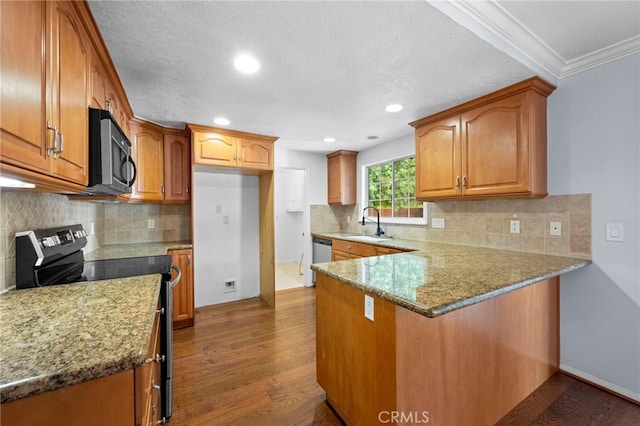 kitchen featuring a peninsula, dark wood-style floors, brown cabinets, and stainless steel appliances