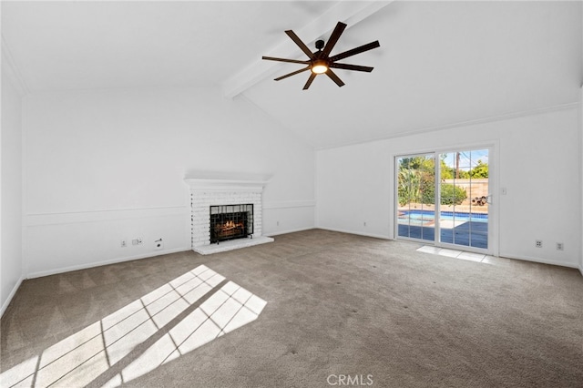 unfurnished living room with beam ceiling, a brick fireplace, ceiling fan, and carpet floors