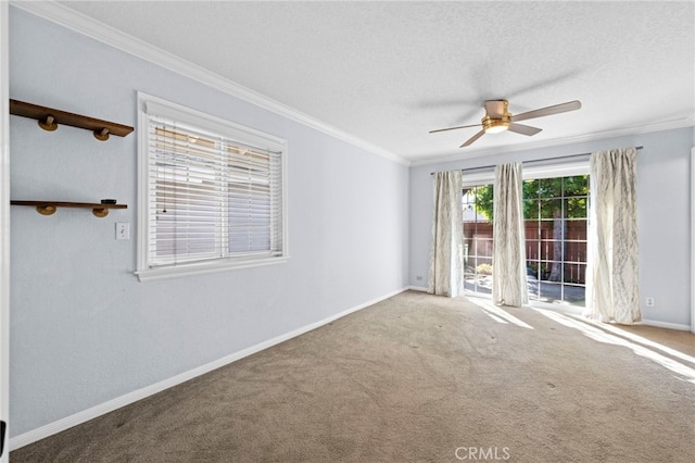 carpeted empty room featuring baseboards, a textured ceiling, a ceiling fan, and crown molding