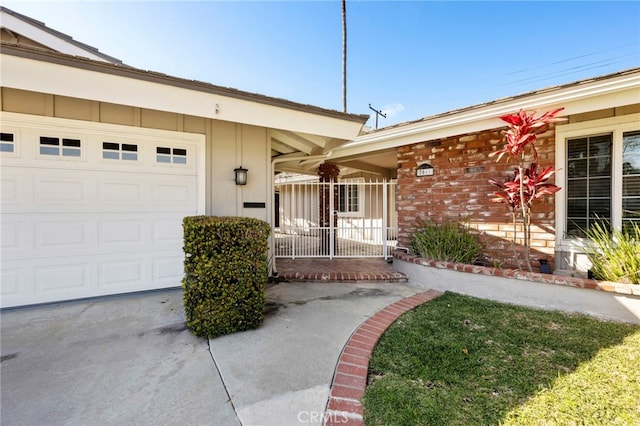 view of exterior entry featuring a garage and driveway