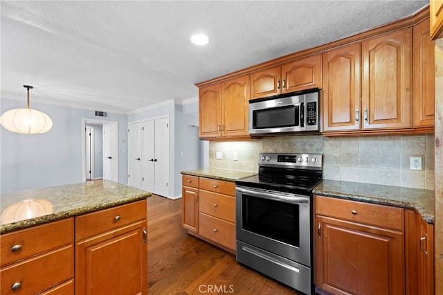 kitchen featuring visible vents, dark wood-type flooring, ornamental molding, stone countertops, and stainless steel appliances