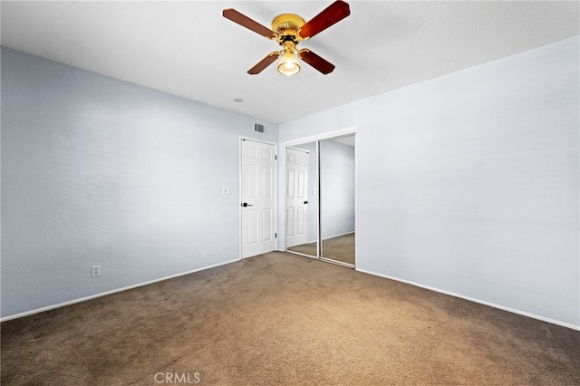 unfurnished bedroom featuring a ceiling fan, carpet flooring, visible vents, and a closet