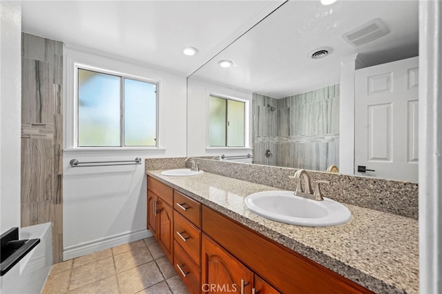 bathroom featuring double vanity, visible vents, a shower, and a sink