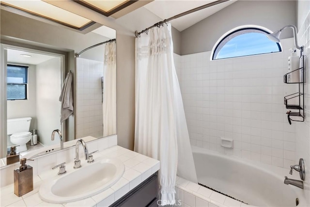 bathroom featuring vanity, toilet, and shower / tub combo with curtain