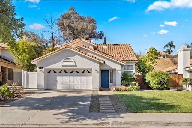 mediterranean / spanish-style home with fence, an attached garage, stucco siding, concrete driveway, and a tile roof