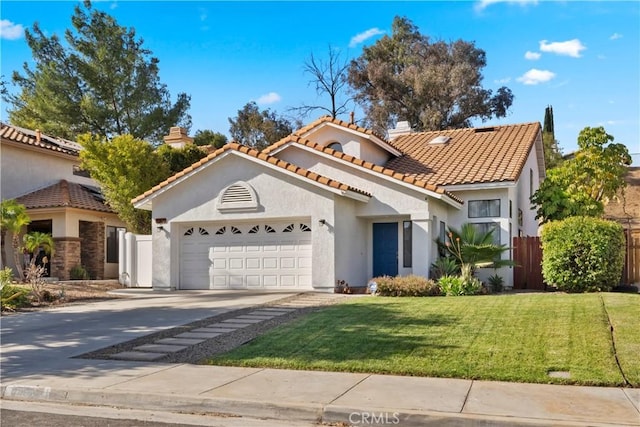 mediterranean / spanish-style house with concrete driveway, fence, a garage, and stucco siding