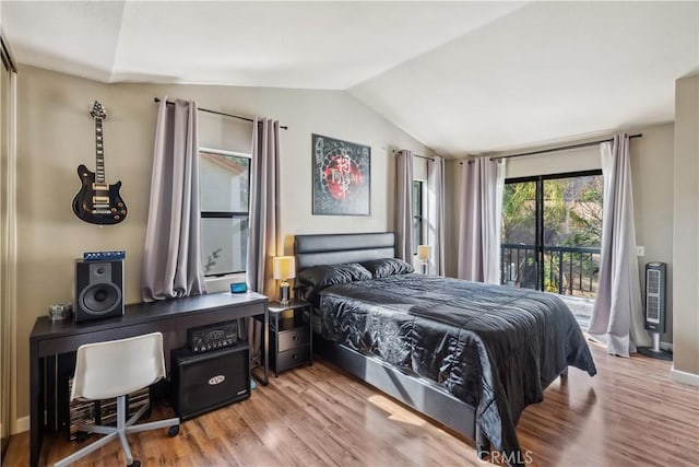 bedroom featuring vaulted ceiling, access to outside, wood finished floors, and baseboards