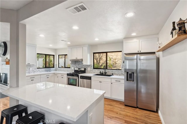 kitchen with visible vents, plenty of natural light, stainless steel appliances, and a sink