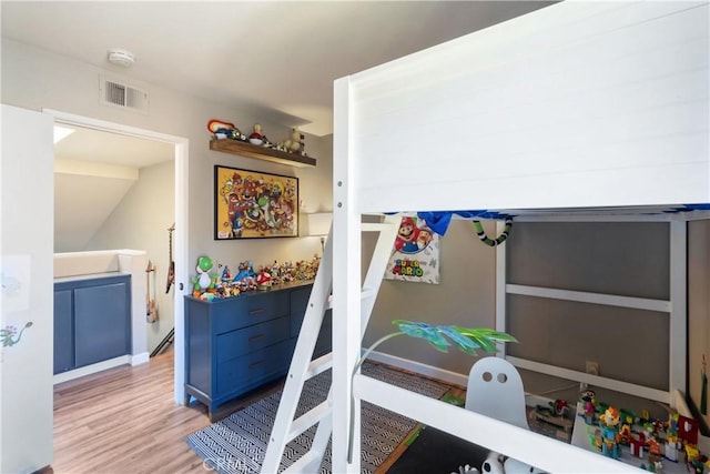 bedroom featuring wood finished floors and visible vents