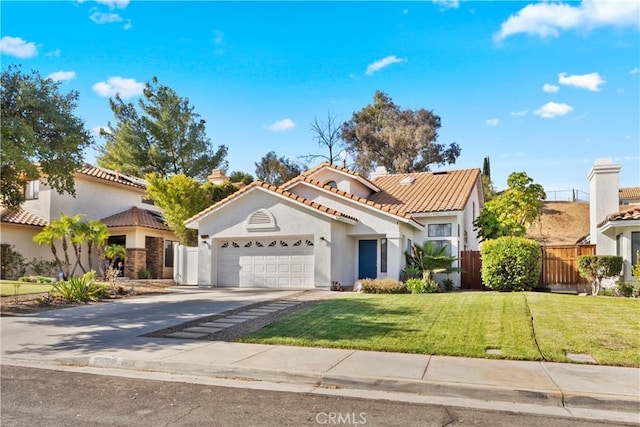 mediterranean / spanish home featuring stucco siding, fence, concrete driveway, an attached garage, and a tiled roof