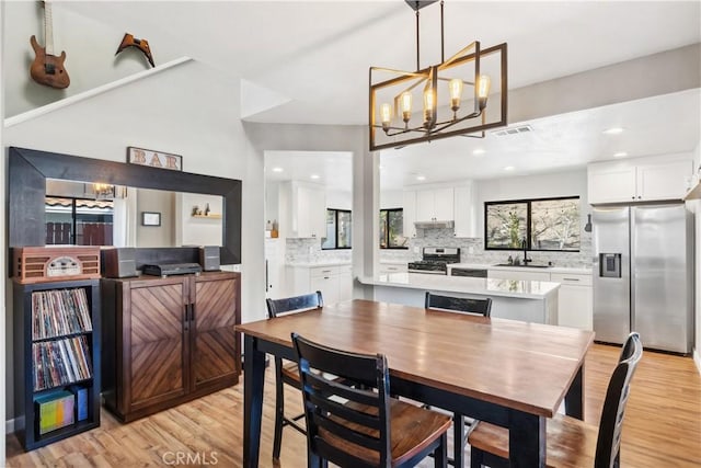 dining space featuring light wood-type flooring, visible vents, a chandelier, and recessed lighting