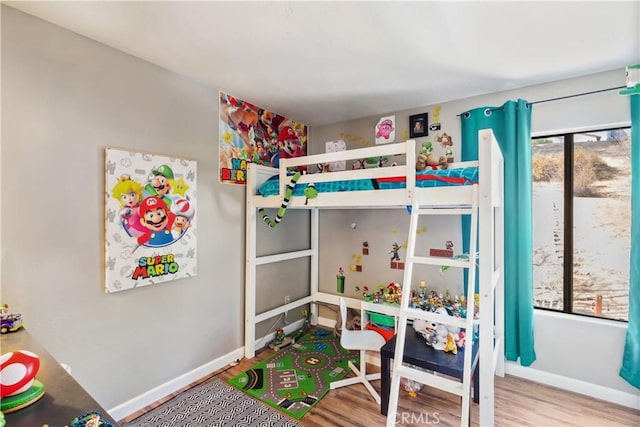 bedroom with baseboards and wood finished floors