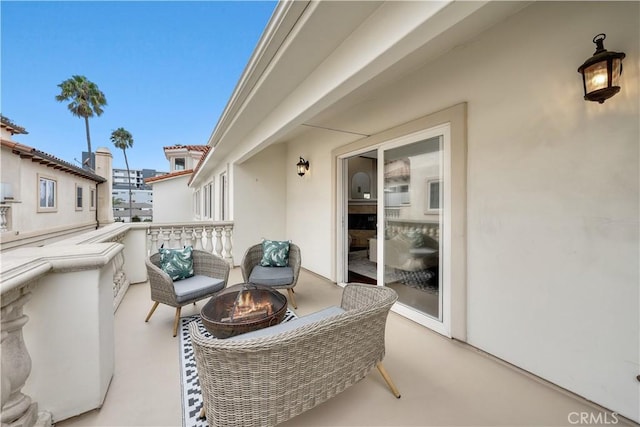 view of patio / terrace with a balcony and an outdoor fire pit