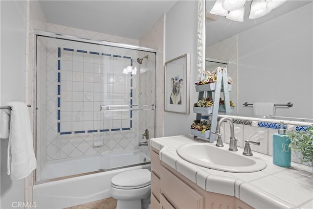 full bathroom featuring vanity, toilet, and shower / bath combination with glass door