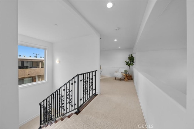 hallway with carpet, recessed lighting, and an upstairs landing