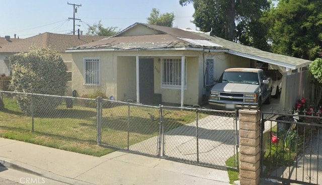 bungalow featuring a carport, a fenced front yard, and stucco siding