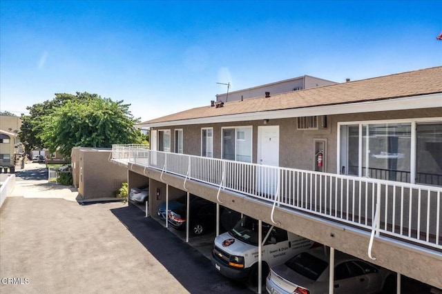 exterior space featuring stucco siding and covered parking