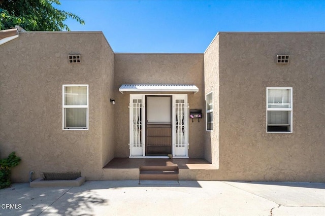 entrance to property featuring stucco siding