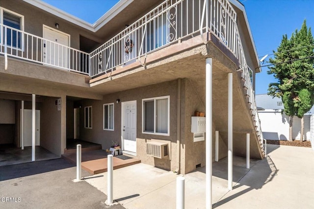 exterior space featuring a wall unit AC and stairway