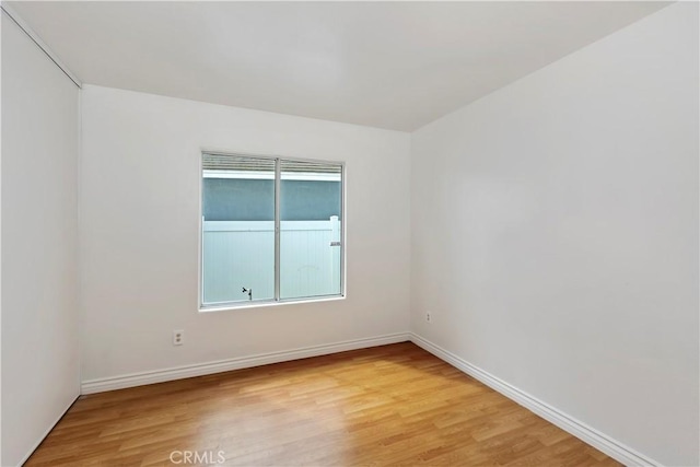 spare room with light wood-type flooring and baseboards