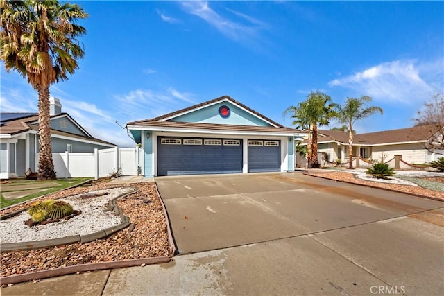 single story home with driveway, an attached garage, and fence