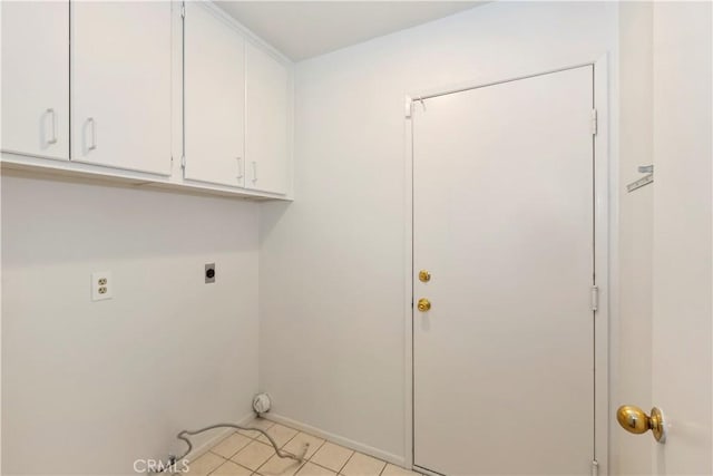 clothes washing area with light tile patterned flooring, cabinet space, and hookup for an electric dryer