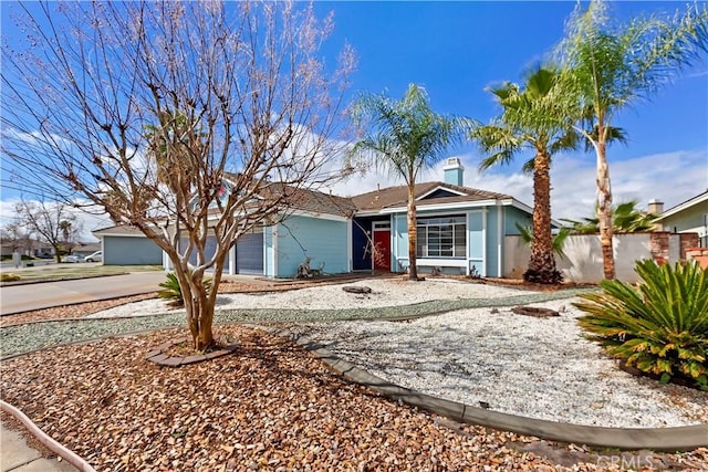 ranch-style home with fence, concrete driveway, stucco siding, a chimney, and an attached garage